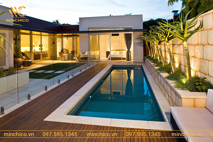 Mẫu hồ bơi sân sau với thiết kế đơn giản. Bức tường bằng kính cường lực có tác dụng ngăn cách, đảm bảo an toàn khi trong nhà có trẻ nhỏ